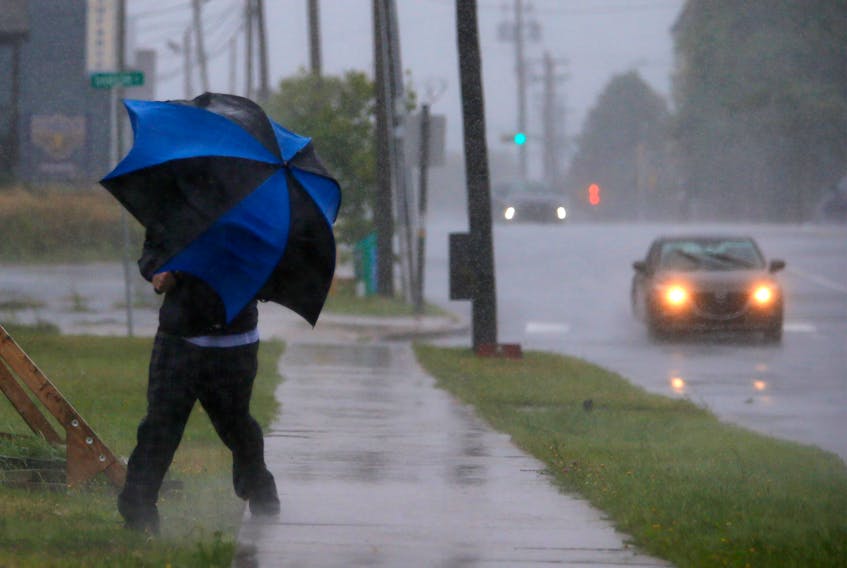 A man gets blown off the sidewalk beneath his umbrella, while walking along Wyse Road during an approaching Hurricane Dorian, in Dartmouth Saturday September 7, 2019.

TIM KROCHAK/ The Chronicle Herald