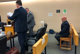 Elementary school principal Robin McGrath sits in a courtroom at provincial court in St. John's at the start of his trial. In front of him are his defence lawyers, Tom Johnson and Ian Patey. McGrath is facing charges of assaulting and threatening special needs children at a school in Conception Bay South. — Tara Bradbury/The Telegram