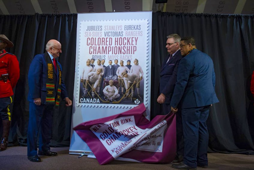 Nova Scotia's Lt.-Gov. Arthur J. Leblanc unveils a new stamp honouring the Colored Hockey Championship with Canada Post president and CEO Doug Ettinger and Craig Smith, president of the Black Cultural Society, at the Black Cultural Centre in Cherry Brook on Thursday, Jan. 23, 2020.