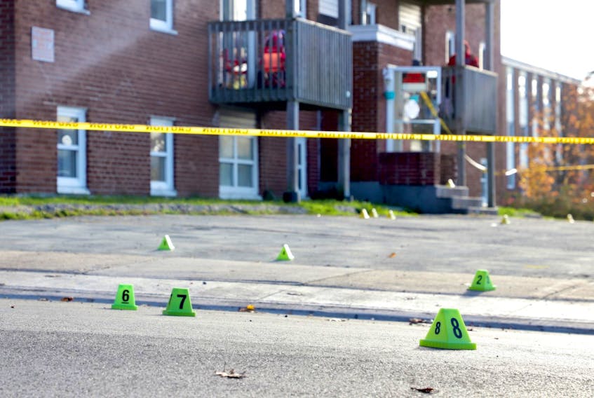Evidence markers and police tape are visible in the parking lot of an apartment building on Primrose Street in Dartmouth on Oct. 23, 2020, after the fatal stabbing of Zachery Grosse, 25, the night before.