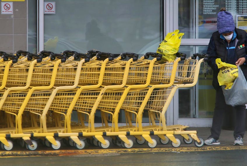 A woman sorts her groceries after leaving a grocery store in Dartmouth on Tuesday, May 12, 2020.