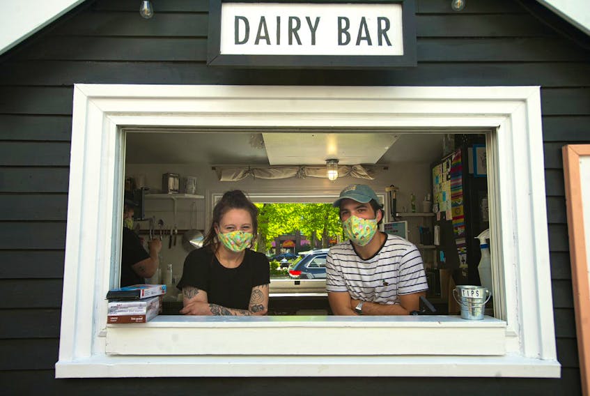 Dairy Bar owners Emma and Sonny Adamski pose for a photo at the window of their South Park Street ice cream shop on Thursday, June 4, 2020.