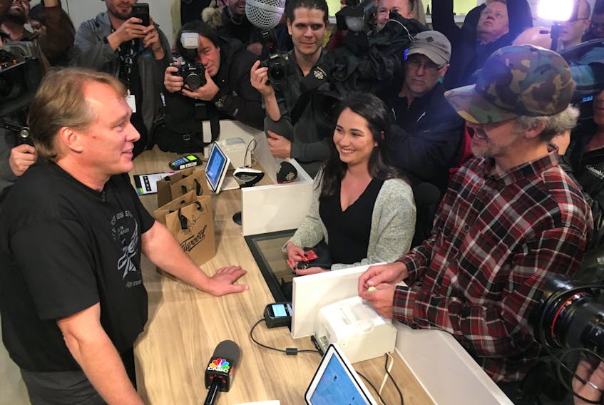 Tweed CEO Bruce Linton (left) launched pot sales in St. John's, Newfoundland and Labrador, at 12:01 a.m. Ian Power (right) and Nikki Rose were the first customers.