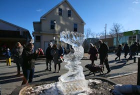 Visitors take photos of some of the ice sculptures completed during the Downtown Dartmouth Ice Festival in Dartmouth on Saturday, Feb. 8, 2020.