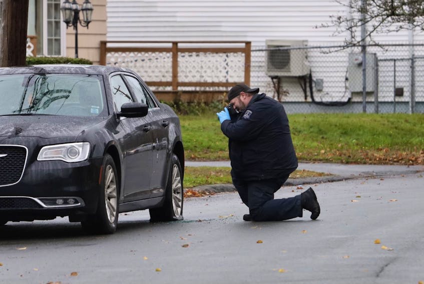A member of the Halifax Regional Police forensics team photographs the damage to a car that was shot at on Leaman Drive in Dartmouth on Tuesday morning, Oct. 27, 2020. Damage included a flat tire and shattered back window.