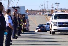 Police, firefighters and other emergency personnel line Garland Avenue in Dartmouth as the body of an RCMP officer is transported to the Dr. William D. Finn Centre for Forensic Medicine for an autopsy Sunday evening, April 19, 2020.
