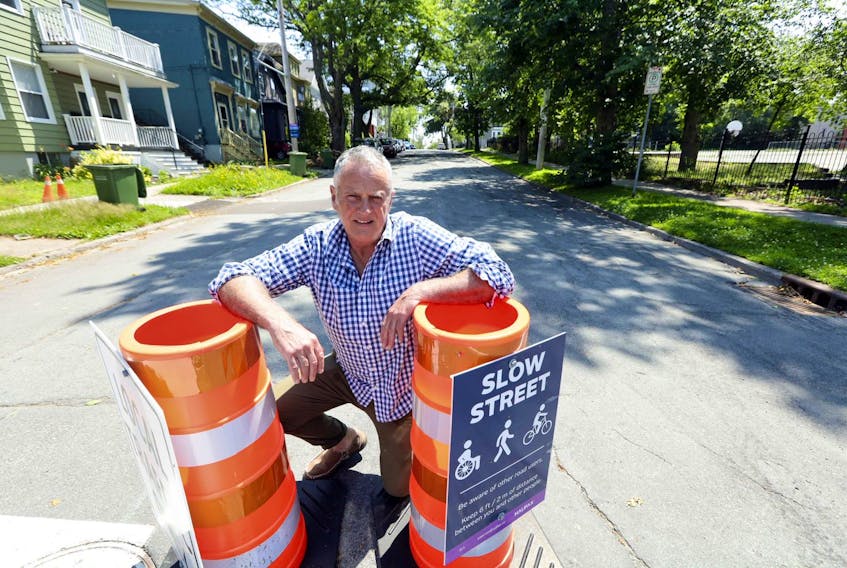 Columnist John DeMont poses for a photo on Walnut Street with pylons designating the residential street as a ‘slow street’.