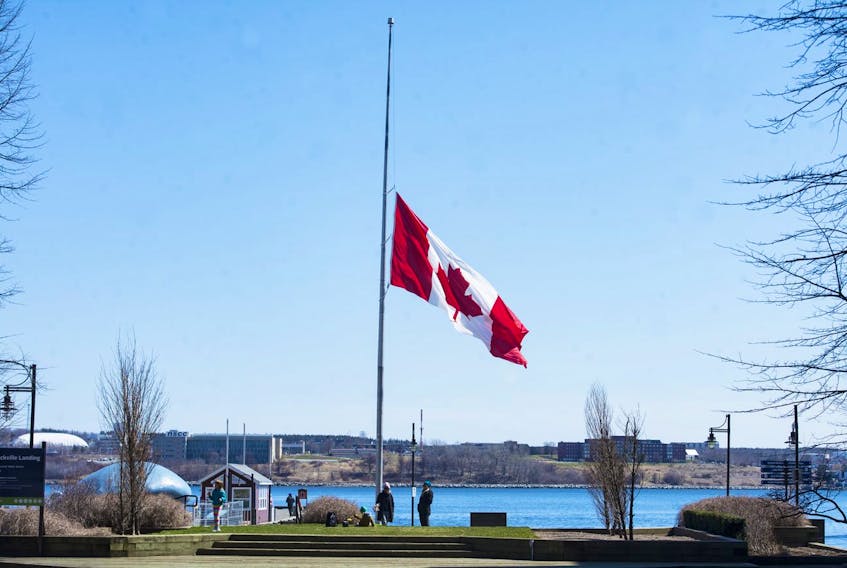 The giant flag near the wave sculpture on the Halifax waterfront flies at half-mast on Tuesday morning,, April 21, 2020 in memory of the victims of the weekend’s mass shootings.