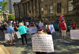 A protester's sign calls for a reduction in class sizes when Nova Scotia public schools reopen in September. The woman was part of a rally by a group of teachers and parents concerned about the safety of the Liberal government's back-to-school plans, held at the entrance to government offices on Granville Street in Halifax on Monday, August 10.