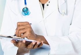 Stock photo of black female doctor holding clipboard.