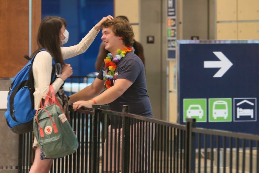 Chloe Puddister plays with the hair of her boyfriend, Hayden Goss, as the couple reunites in the baggage area of Halifax Stanfield International Airport on Thursday, July 2, 2020 after spending the last three-and-a-half months apart. Chloe had just arrived from a flight from St. John's.