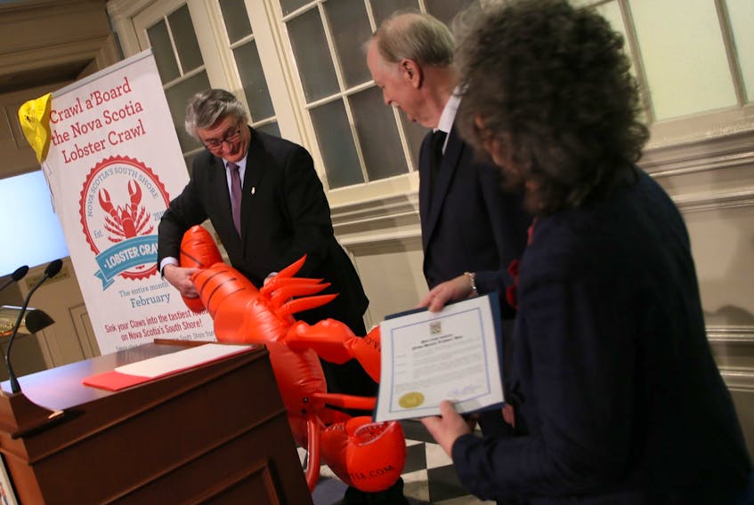 Hugh MacKay, MLA for Chester-St. Margaret's, wrangles an inflatable lobster after reading the proclamation announcing Lobster Day, which will be held Feb. 28. as Fisheries Minister Keith Caldwell watches at Province House on Wednesday, Jan. 29, 2020.