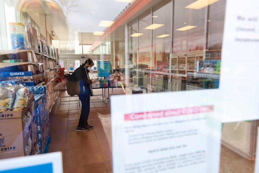 A staff member waits inside the Superstore in Bedford on Friday, March 27, 2020, after the grocery store was shut down and shoppers told to leave.