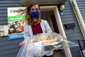 Development assistant Cassidy Shatford holds one of the turkey meals handed out by Family SOS in Halifax on Thursday afternoon, Dec. 11, 2020.