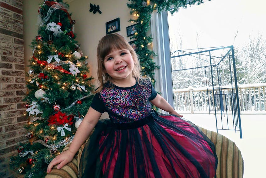Violet McInnis, 3, wears her favourite dress to have her photo taken in front of her family's Christmas tree Wednesday, Dec. 18, 2019.