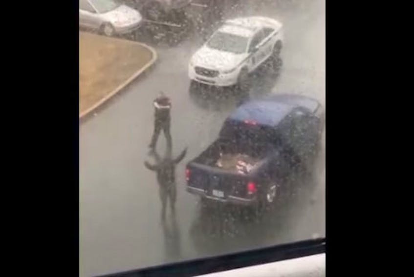 A Halifax Regional Police officer points his gun at a man with his hands in the air in this screengrab from video. The confrontation happened Friday, March 26, 2021, outside an apartment building at 210 Wentworth Dr. in Halifax. - Screengrab / DeRico Symonds' Facebook page