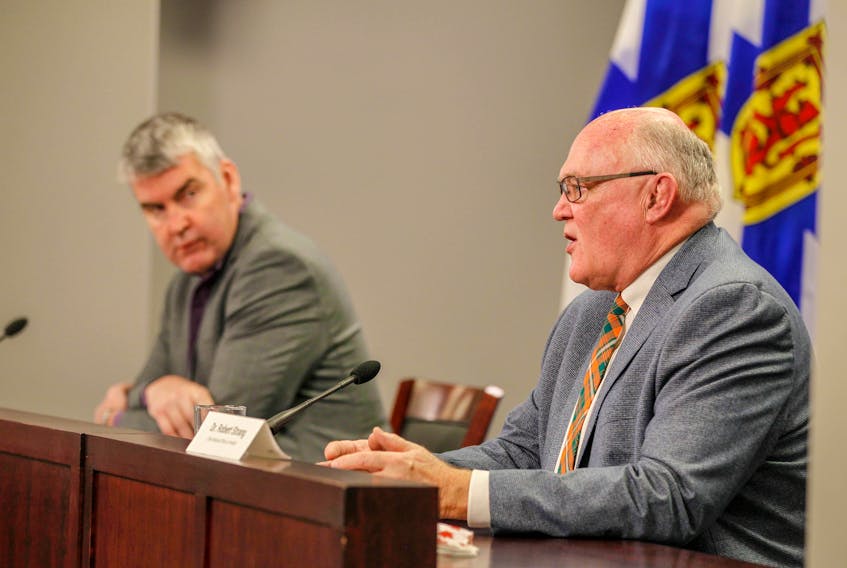 Premier Stephen McNeil listens as Dr. Robert Strang, Nova Scotia's chief medical officer of health, speaks at a COVID-19 briefing on Friday, Jan. 22, 2021 in Halifax.