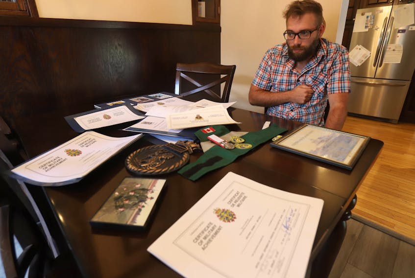 Former Leading Seaman David Gechell displays some of the memorabilia from his time serving aboard HMCS Windsor at the kitchen table of his Dartmouth home Friday, Sept. 11, 2020. Getchell suffered a medical condition aboard the sub, just before a visit to the vessel by Prince Charles in 2015.