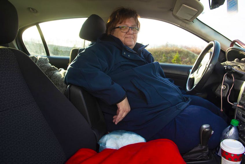 Joni Rutledge sits inside her Pontiac sedan in the parking lot of the Dartmouth Crossing Walmart on Wednesday, Dec. 4, 2019. Rutledge was fired from her job and was evicted from her apartment in the summer. She's been living in her car for the last several months.