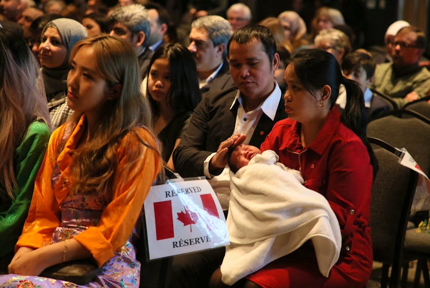Miguel Mercader, strokes the head of his son Elijah, who was stirring in the arms of his wife Apol during a Canadian citizenship ceremony in Halifax on Wednesday, Jan. 15, 2020. The family, which also includes daughter, Meg and son Carl (not in photo), were some of  the 50 new citizens sworn in at a special citizenship ceremony held at the Canadian Museum of Immigration at Pier 21.