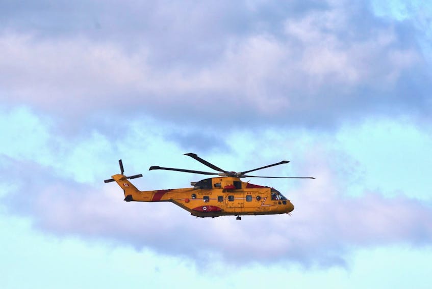 A Cormorant helicopter flies near Parkers Cove, Annapolis County, on Wednesday, Dec. 16, 2020 as part of a search for the missing crew of the scallop boat Chief William Saulis, which went missing early the previous morning. The body of one of the six men aboard was recovered the previous night.
