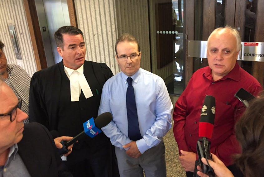 Glen Assoun, centre, his lawyer Sean MacDonald, left, and Ron Dalton, co-founder of Innocence Canada, discuss the release of hundreds of documents in Assoun's wrongful murder conviction case Friday, July 12, 2019, outside Nova Scotia Supreme Court in Halifax.
