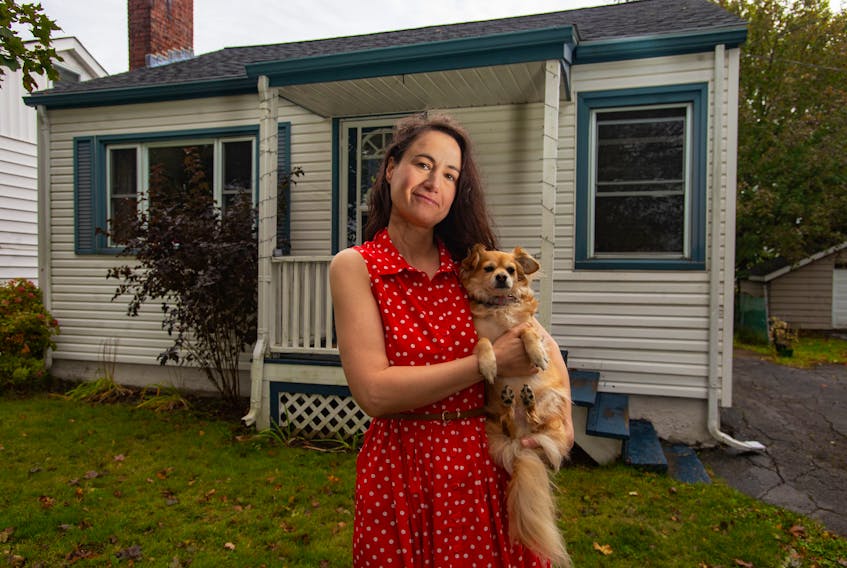Erica Maxwell poses for a photo with her dog Meg in front of their Halifax home on Tuesday, Oct. 8, 2019. Maxwell's basement recently flooded with sewage after Halifax Water did some work in the area.
