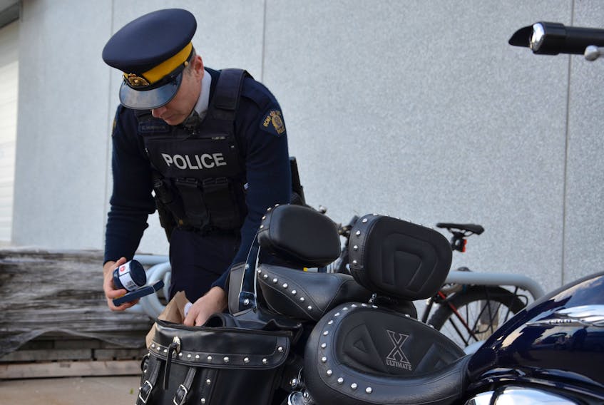Const. Chad Morrison demonstrates how to properly store cannabis for transportation on a motorcycle at the RCMP headquarters in Dartmouth on Wednesday, Oct. 9, 2019.