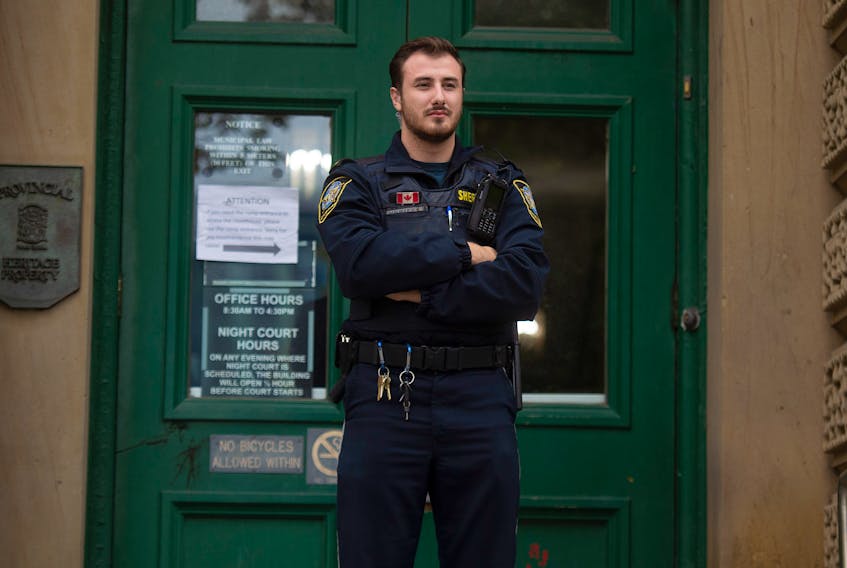 A deputy sheriff stands in front of the doors to Halifax provincial court after the courthouse was closed because of an altercation inside the building on Thursday morning, Oct. 10, 2019.