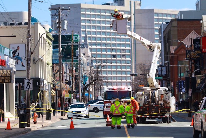 Crews work over the lunch-hour to restore a line that crosses Spring Garden Road in Halifax after high winds caused it to break off and land in the street Thursday, April 4, 2019. Spring Garden Road was closed between South Park and Dresden Row to allow for the repair.