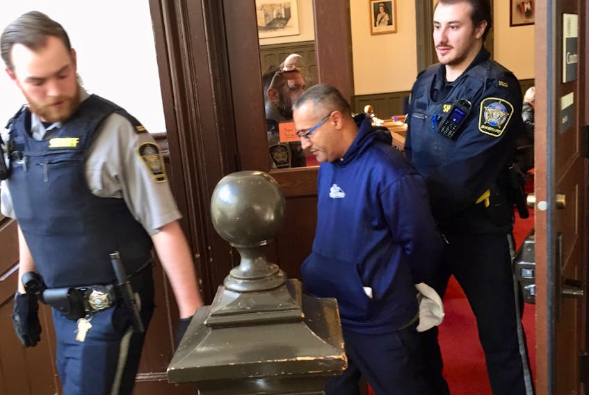 David Sadik, a Dutch national who has allegedly lived in Nova Scotia for 19 years under another name, is led out of Halifax provincial court Wednesday, Nov. 27, 2019 after being arraigned on immigration and fraud charges.