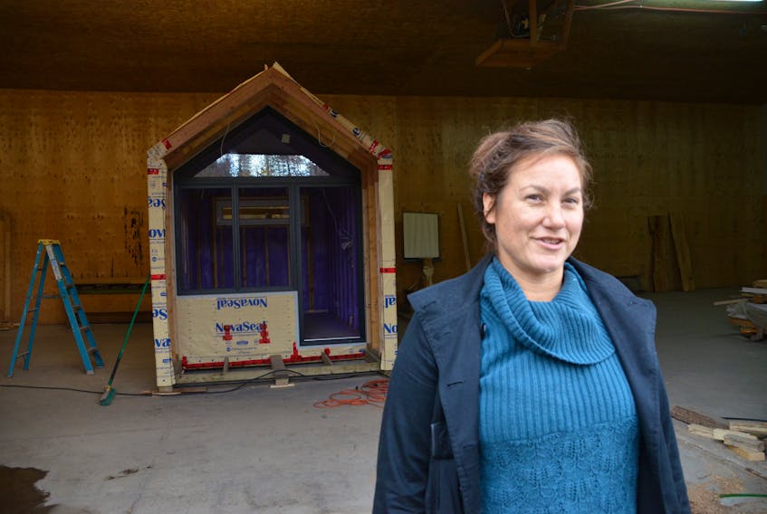 Stacie Carroll, business development co-ordinator for the Breton Forest Co-operative, stands in front of the co-op's partially constructed first tiny home.