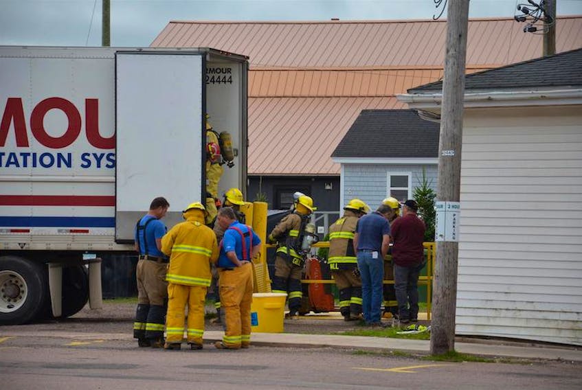 Members of the Kensington Fire Department address a sodium hydroxide leak from a refrigerated trailer parked at the Kensington Food Basket on Tuesday morning.