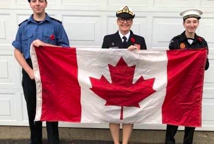 Lt.-Cdr. Karen O'Connell (centre) with her son, Logan Burke, sea cadet sailor third class, and daughter, Madison Burke, master cadet. The family, including O'Connell's husband, Wayne Burke, a retired bosun, donned their uniforms for a stay-at-home Remembrance Day Wednesday.