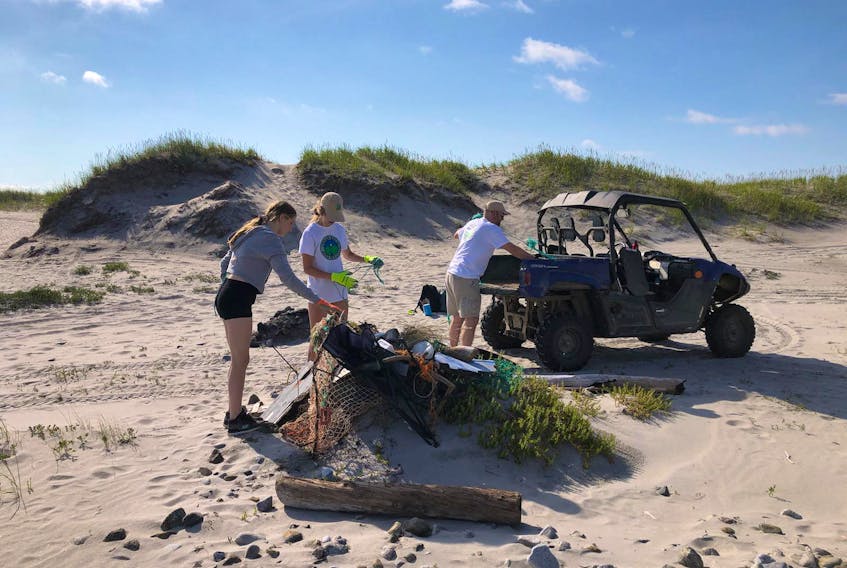 The Indian Bay Ecosystem Corporation is working to clean the Cape Freels beach area and track the shorebirds that nest there as a part of its work to be environmentally sound in Bonavista North. Shown here (from left) are Candace Parsons, Danielle Rogers and manager Darren Sheppard in Cape Freels recently. — Photo courtesy Darren Sheppard 