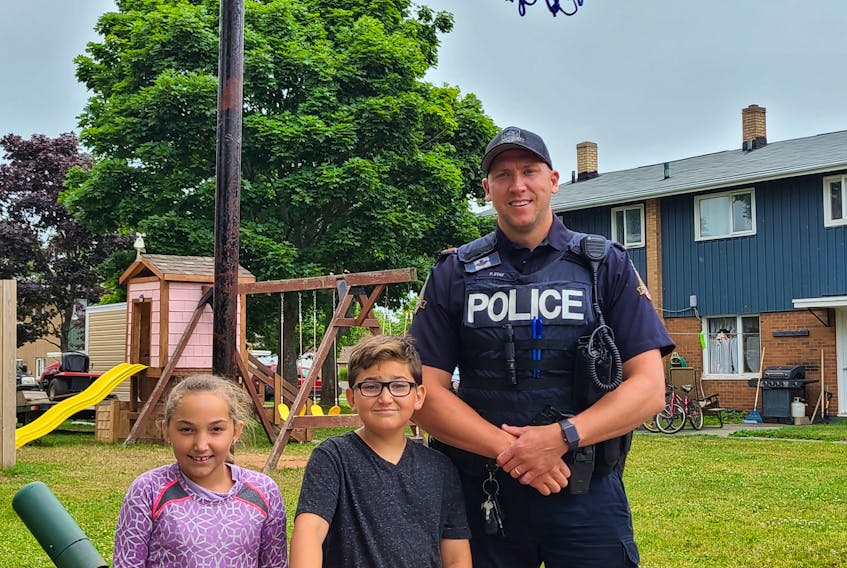 Ten-year-old Kingston Gallant, centre, and his sister, Arden, 9, have been hanging out with Summerside Police Services Const. Peter Stay a lot this past month. Kingston and Peter love to shoot hoops.