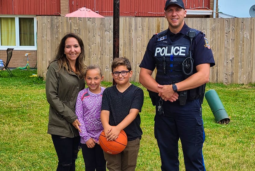 When Tara-Lynn Rioux heard her son Kingston, holding the basketball, wouldn’t go outside because he was afraid of police she called Summerside Police Services. Const. Peter Stay was there within the hour. Stay and Kingston have since formed a tight bond. Also pictured is Kingston’s sister, Arden.
