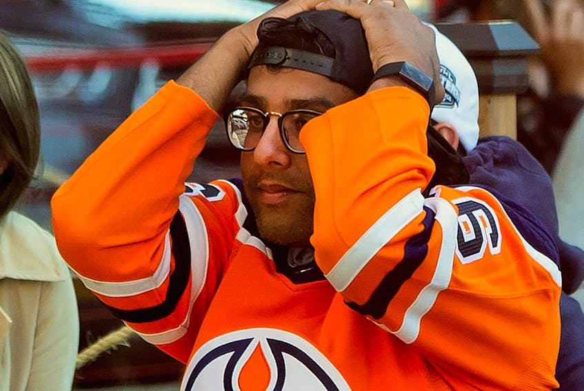 An Edmonton Oiler fan reacts to the team's loss to the Chicago Blackhawks and elimination from the NHL playoffs in downtown Edmonton on Friday, Aug. 7, 2020.