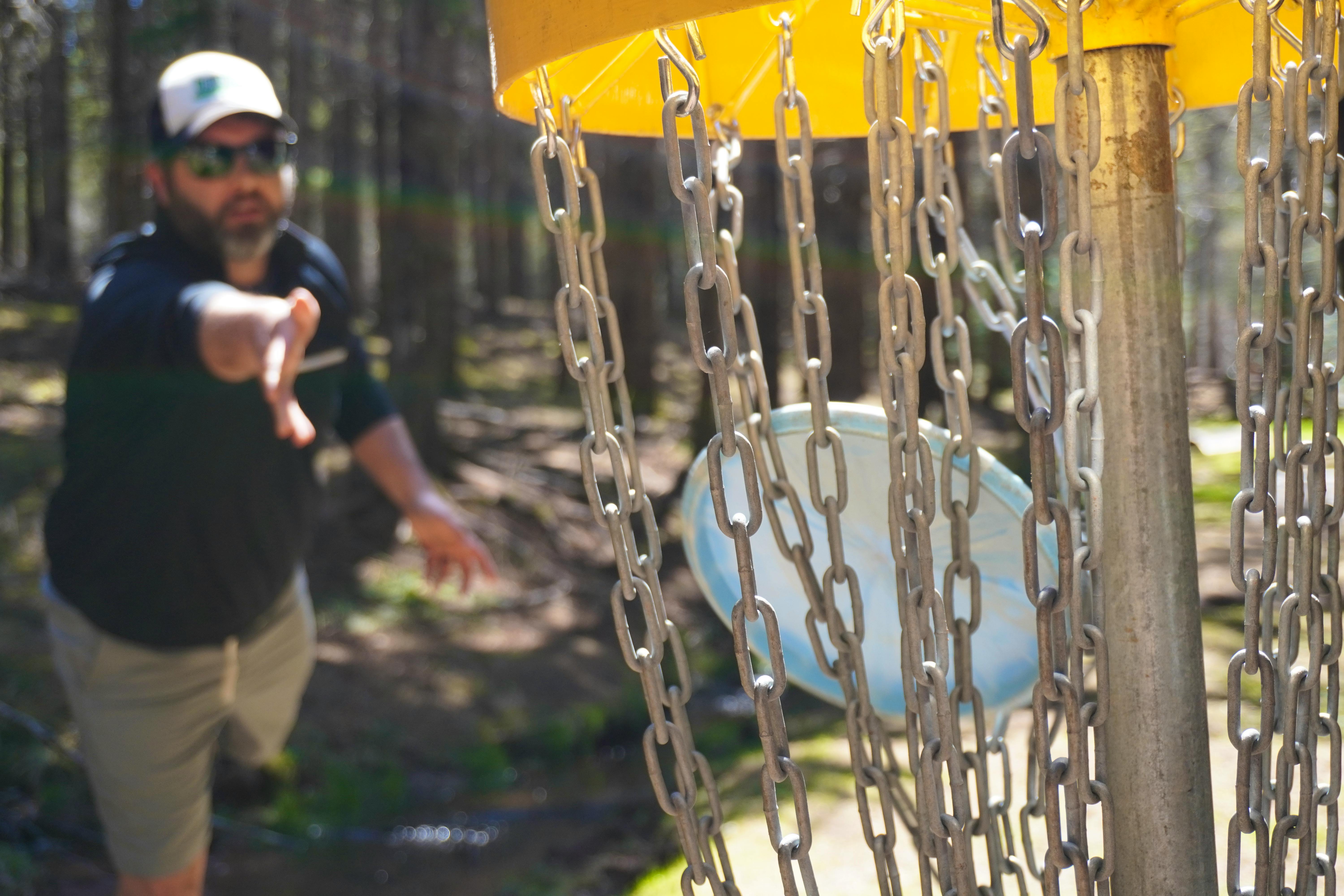 Jacob Smith, owner of Island Disc Golf Company, hits the target at Hillcrest Farm Disc Golf in Bonshaw on May 20.