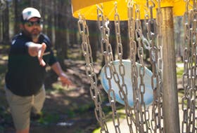 Jacob Smith, owner of Island Disc Golf Company, hits the target at Hillcrest Farm Disc Golf in Bonshaw on May 20.