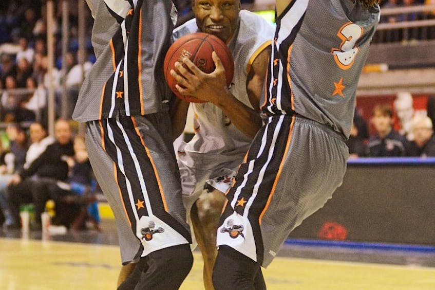 Antonio Ballard of the Island Storm looks for a way to squeeze through the Moncton Miracle defenders during NBL of Canada playoff action Monday night in Charlottetown. <br /><br />