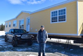 Blair van Veld stands by one of the homes nearing completion at Twin Rivers Home Building. 