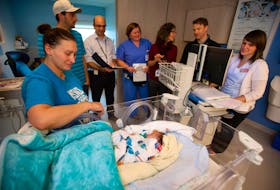 A medical assessment team visits baby Nathan Mazerolle and his family in the IWK Health Centre neonatal intensive care unit. From left,  Nathan's mom Rachelle Henrie of Bouctouche, N.B., dad Julien Mazerolle, Dr. Jon Dorling, head of neonatal-perinatal medicine, nurse practitioner Arthena MacDonald, neonatal dietitian Joyce Ledwidge, pharmacist Andrew Veysey and charge nurse Bev Fiddler. - Ryan Taplin