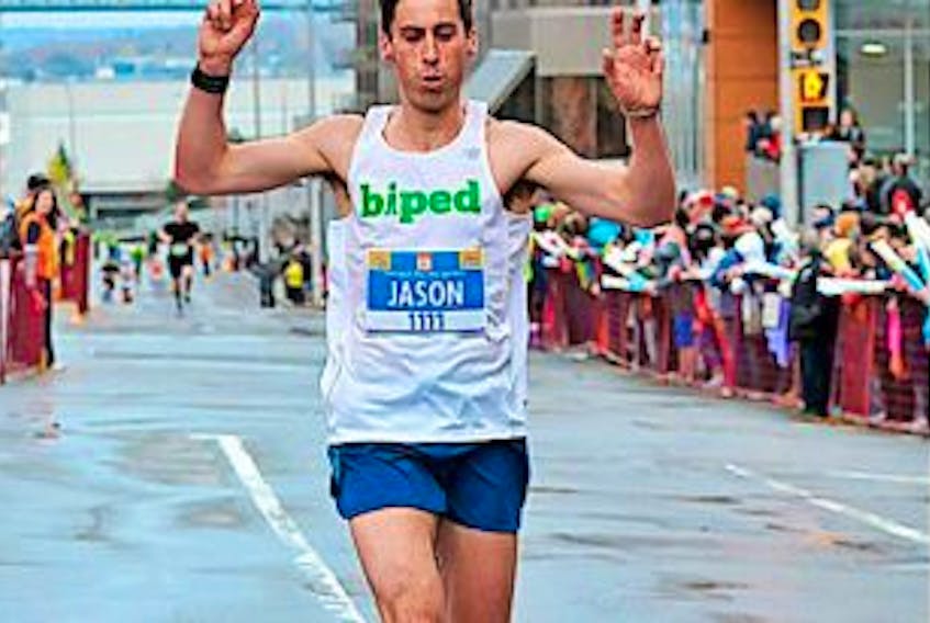 ['Corner Brook native Jason Guy acknowledges the crowd after crossing the finish line in the half-marathon event at the 2015 Scotiabank Bluenose Mararthon in Halifax. — Submitted photo']