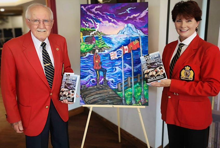 Retired RCMP Superintendent  George Powell stands with author Helen C. Escott at the book launch her book "In Search of Adventure — 70 Years of the RCMP in Newfoundland and Labrador. " The painting between them is by Darrin Martin. – Andrew Waterman/The Telegram