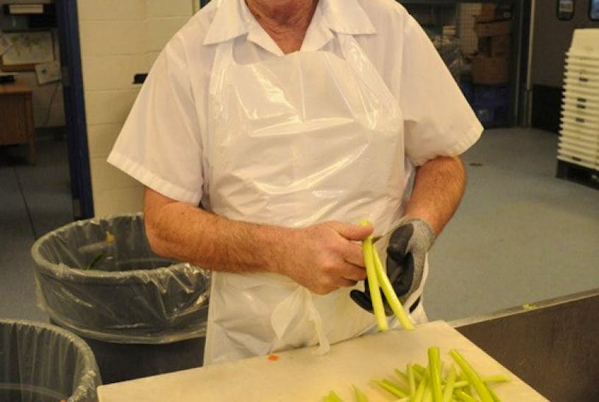 Joe Bennett, a food service worker at Eastern Health's central kitchen in St. John's, cuts celery sticks for a soup mixture at the facility Thursday morning. - Photo by Joe Gibbons/The Telegram