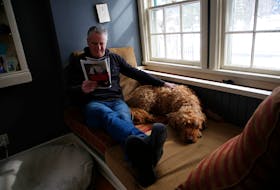John Demont relaxes with his dog, Auggie, in his Halifax home on Monday.

TIM KROCHAK PHOTO