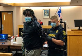 A sheriff prepares to escort Toussaint Yenga-Yenga from a courtroom at provincial court in St. John's Friday morning, after he was sentenced to five months in prison for his role in an identity theft scheme. TARA BRADBURY/THE TELEGRAM