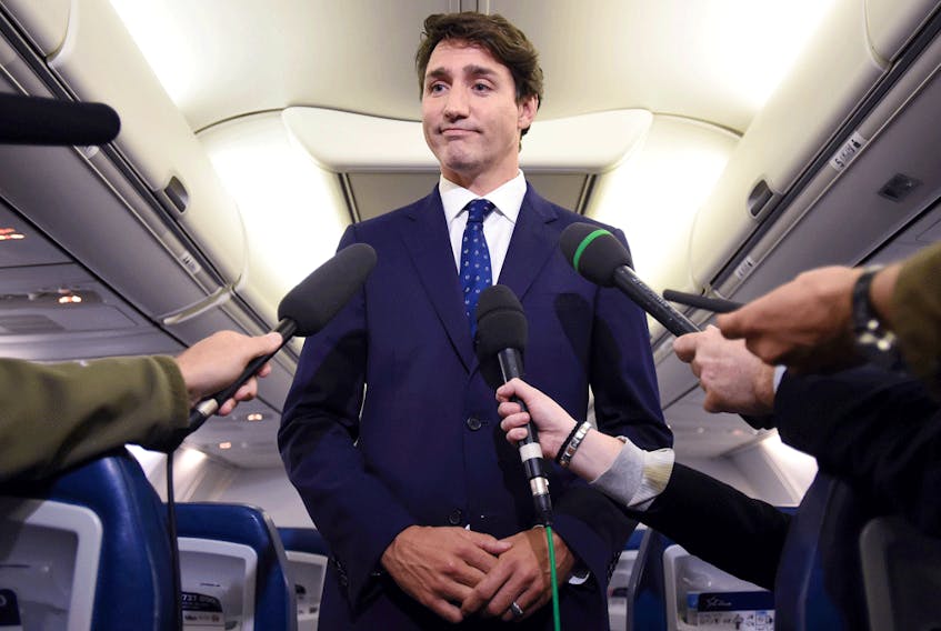 Liberal Leader Justin Trudeau speaks on his campaign plane regarding a 2001 photo that surfaced of him wearing brownface, Sept. 18, 2019.