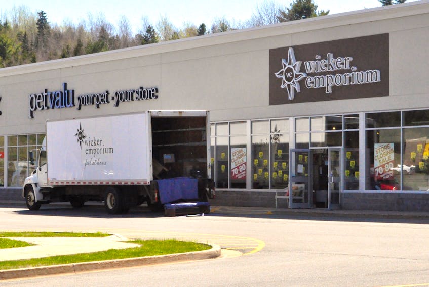 A delivery truck and sale stickers cover Wicker Emporium's New Minas location, which will close its doors permanently between the end of May and early June.